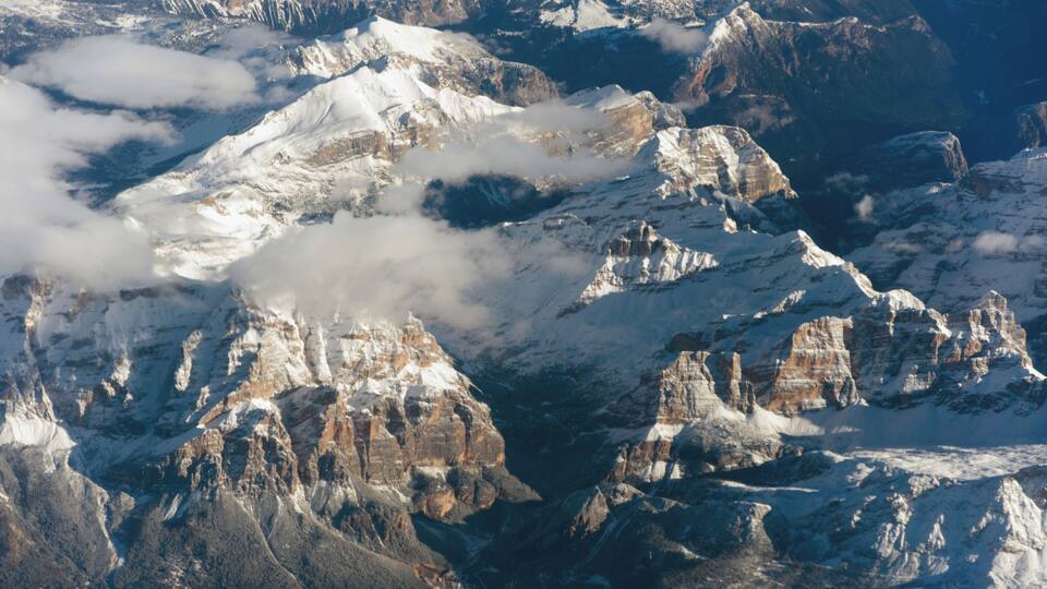 A snow-covered mountain range with rugged peaks and valleys.