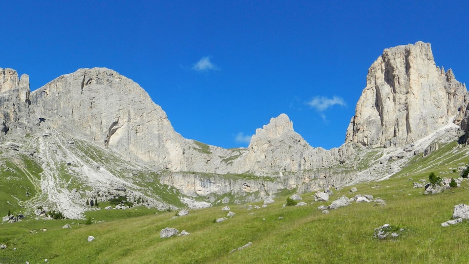 A mountainous landscape with rocky cliffs and green grass.