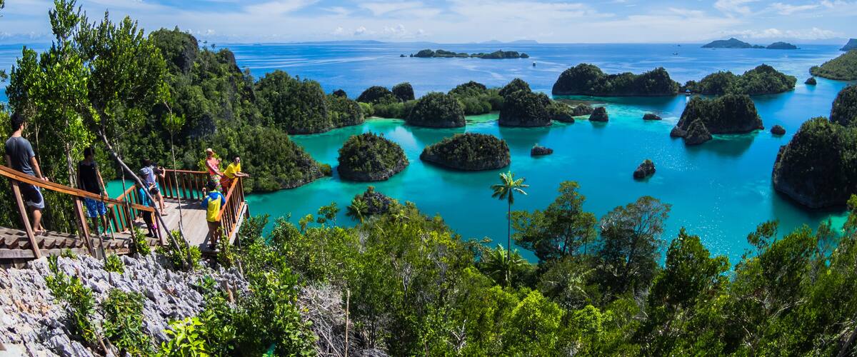 A tropical island landscape with turquoise waters, lush greenery, and rocky outcrops.