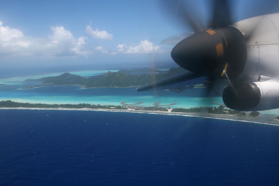 plane over pacific island at takeoff from airport