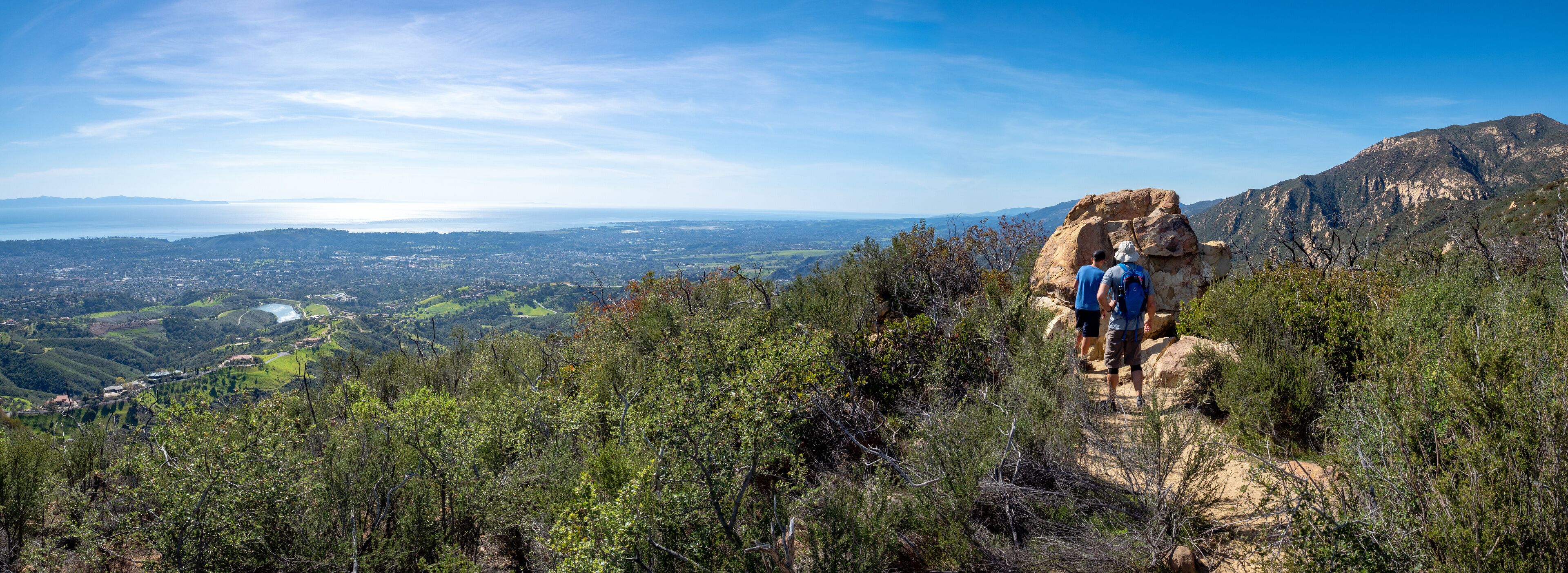 Father and son hiking on Jesusita Trail with panoramic view of ocean and Channel Islands, Santa Barbara, California, USA