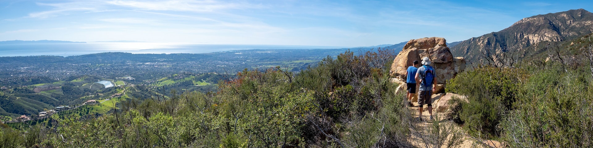 Father and son hiking on Jesusita Trail with panoramic view of ocean and Channel Islands, Santa Barbara, California, USA