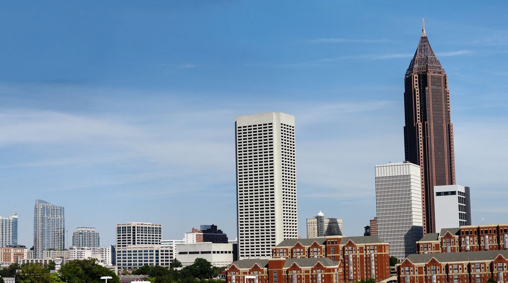 Downtown Atlanta Skyline showing several prominent buildings, apartments, offices and hotels under a blue sky.