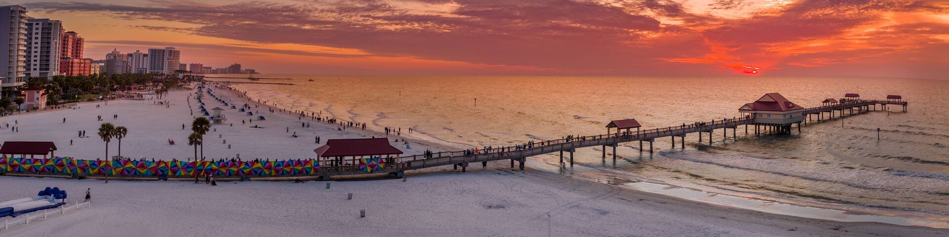 Sunset at Clearwater beach with Pier 60 fishing pier, white sand beach dramatic colorful sky