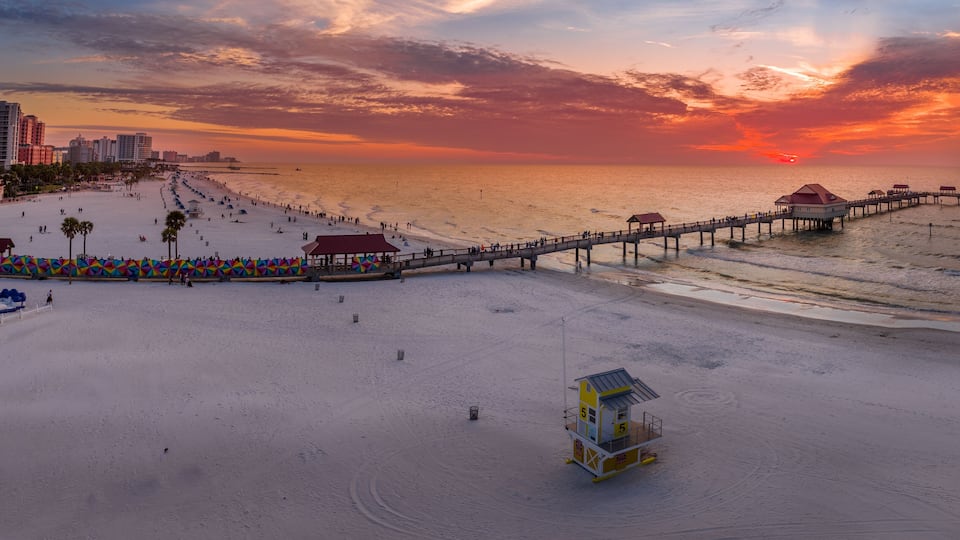 Sunset at Clearwater beach with Pier 60 fishing pier, white sand beach dramatic colorful sky