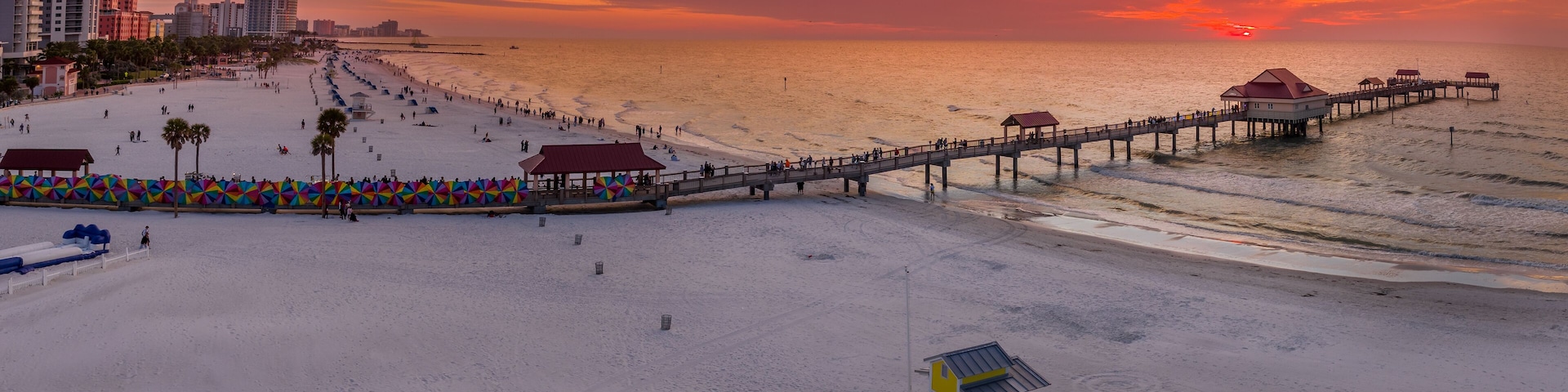 Sunset at Clearwater beach with Pier 60 fishing pier, white sand beach dramatic colorful sky