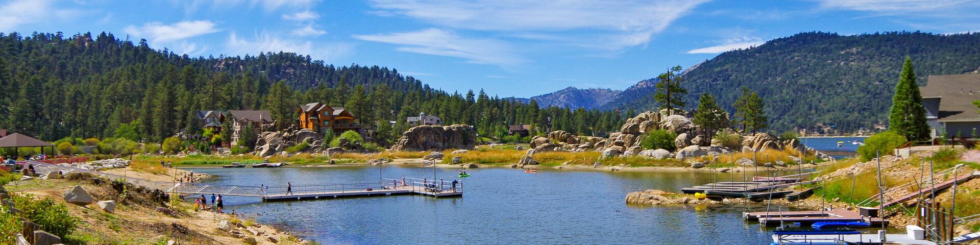 Panoramic view of Big Bear Lake in southern California with lakeside houses and people canoeing and kayaking