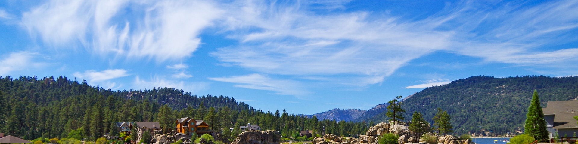 Panoramic view of Big Bear Lake in southern California with lakeside houses and people canoeing and kayaking