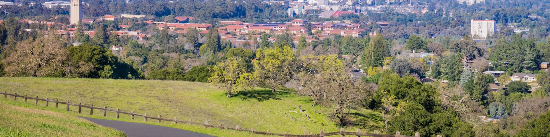 Paved running trail on the Standford dish surrounding hills; Stanford campus, Palo Alto and Silicon Valley skyline in the background, San Francisco bay area, California