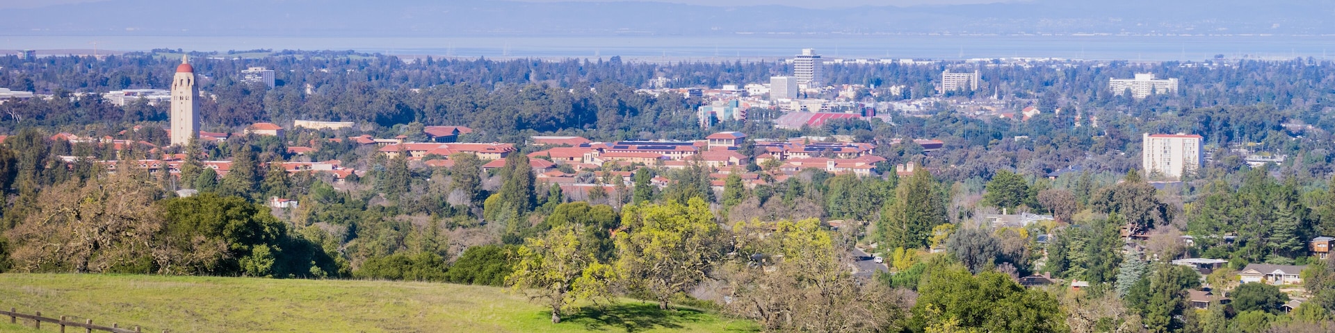 Paved running trail on the Standford dish surrounding hills; Stanford campus, Palo Alto and Silicon Valley skyline in the background, San Francisco bay area, California
