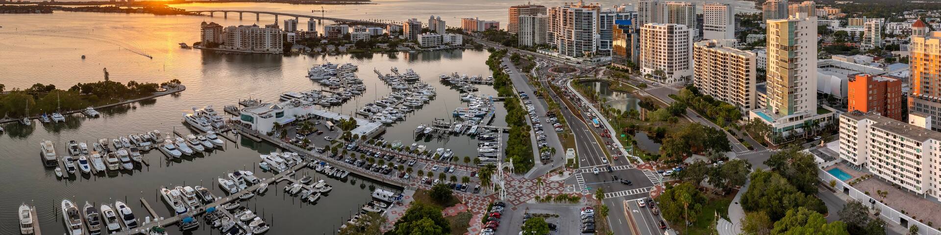 Above view of Sarasota city, Florida with yachts in bay harbor and waterfront office high-rise buildings. Development of housing and transportation in the US