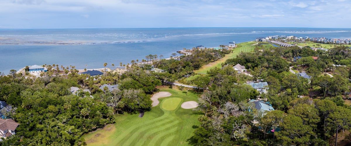 A coastal golf course with a view of the ocean and beach.
