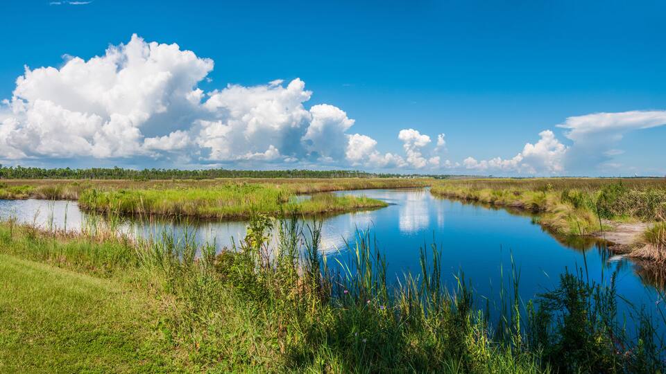Panorama of canals in Gulf Shores State Park in Alabama USA with reflections of sky on water