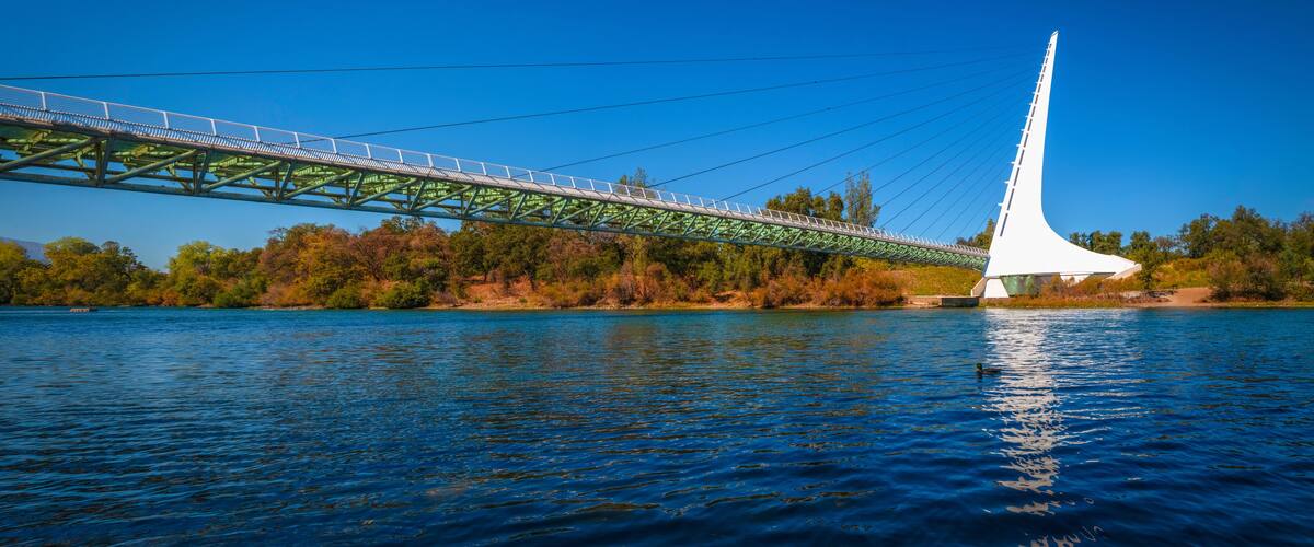 Panoramic autumn landscape at Sacramento River and wildlife animal sanctuary with the view of Sundial Bridge in Redding, Northern California