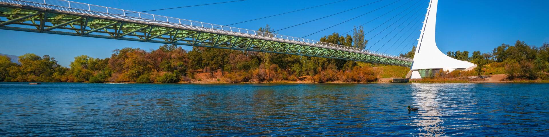 Panoramic autumn landscape at Sacramento River and wildlife animal sanctuary with the view of Sundial Bridge in Redding, Northern California