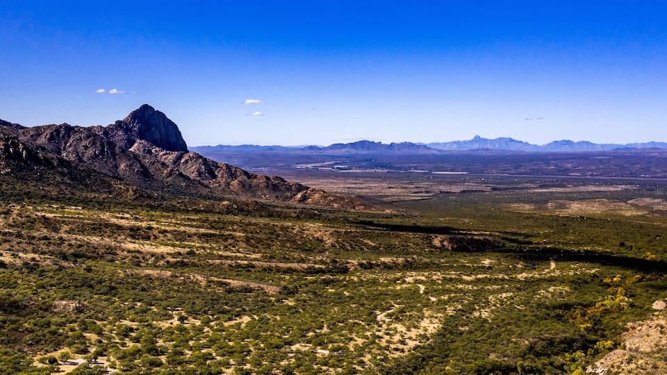 Aerial panorama of Madera Canyon in the Santa Rita Mountains, Arizona in the Fall with purple mountains, green, yellow, orange trees and bushes, blue sky