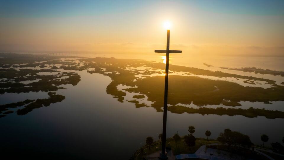 Aerial view of serene marsh with cross silhouette at sunset, St. Augustine, Florida, United States.