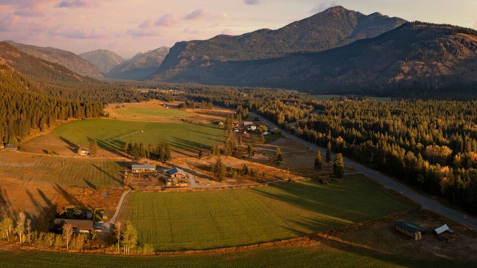 Aerial Panoramic View of the Historic Methow Valley in Eastern Washington State. Farm and ranch land lead to the North Cascade Mountains in this stunning landscape photographed on an autumnal morning.