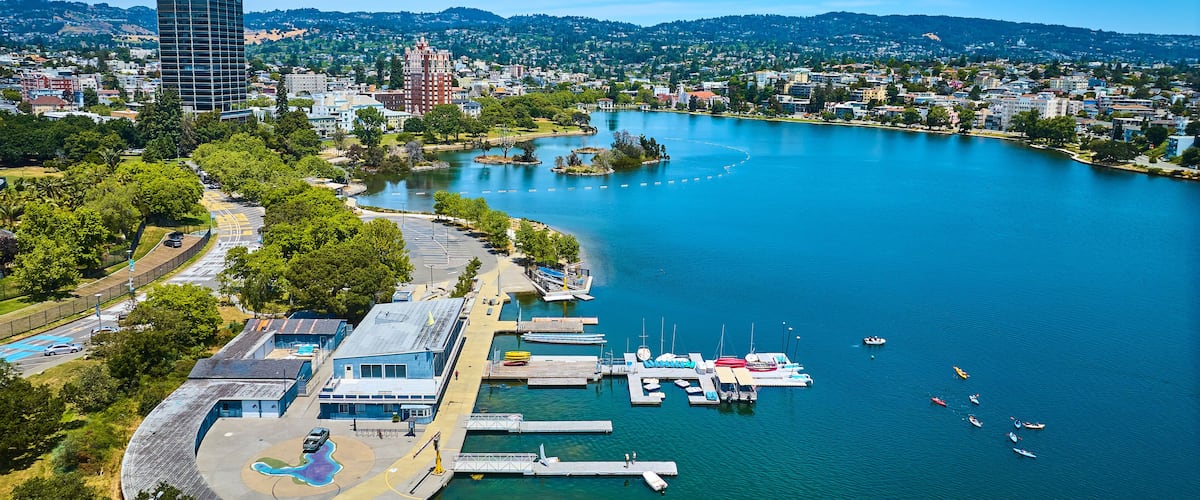 Aerial boating center on Lake Merritt with Pelican Island in distance with buildings along shore