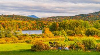 Lake Iroquois surrounded by forests in brilliant fall foliage colors with Camel's Hump Mountain in the distance