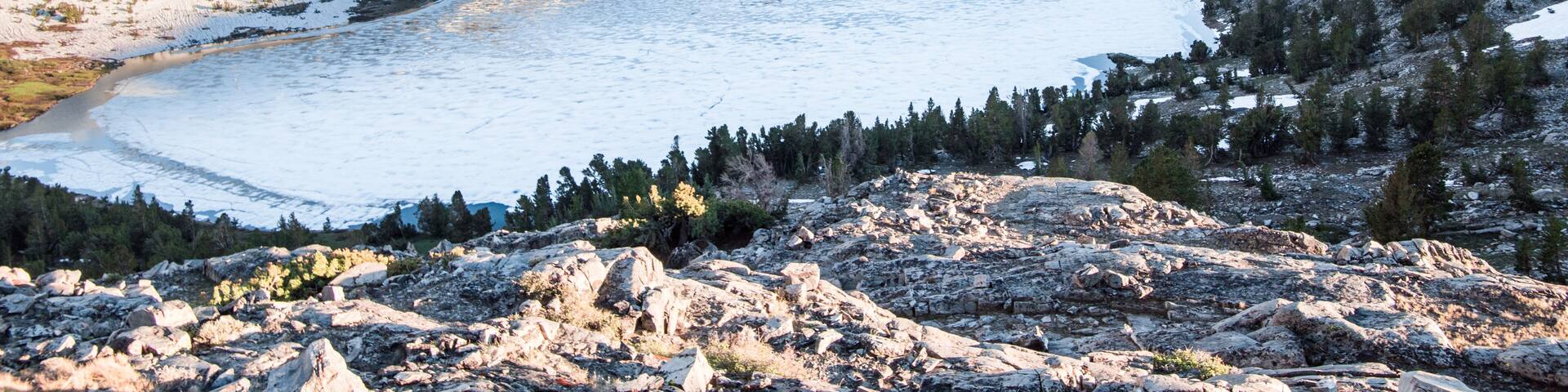 A glacial lake surrounded by rugged mountains and sparse forests.
