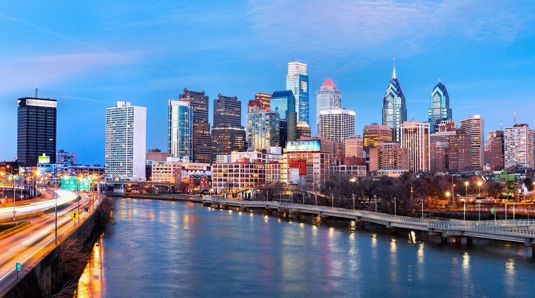 Philadelphia skyline panorama at dusk. Schuylkill expressway traffic runs parallel to Schuylkill river.