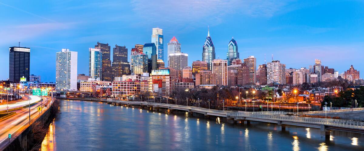 A city skyline with a river and a bridge.