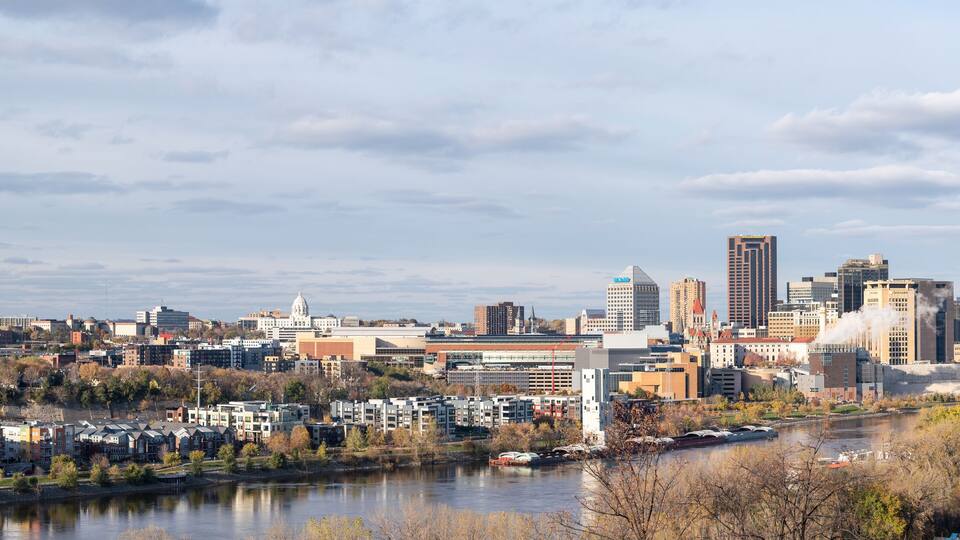 A city skyline with a river, historic buildings, and modern skyscrapers.