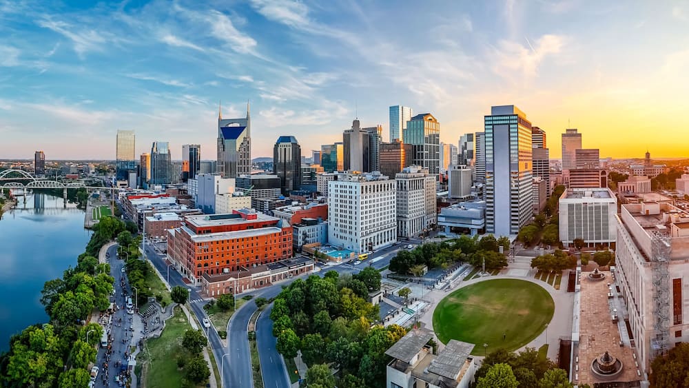 Panoramic view of Nashville skyline at sunset with river, skyscrapers, and city landmarks