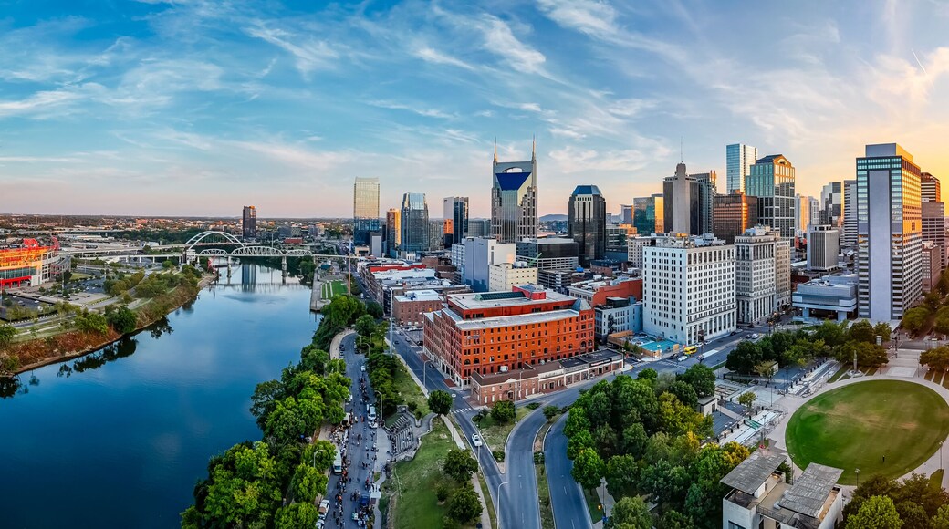 Panoramic view of Nashville skyline at sunset with river, skyscrapers, and city landmarks