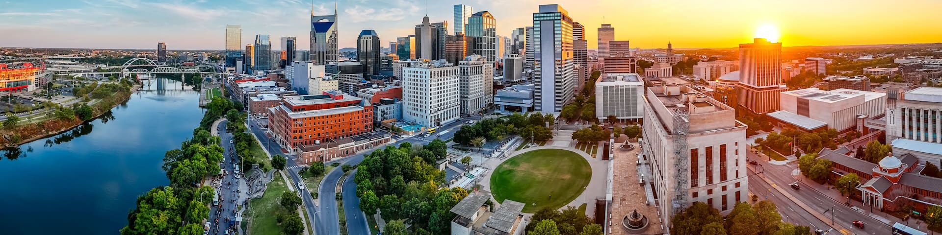 Panoramic view of Nashville skyline at sunset with river, skyscrapers, and city landmarks