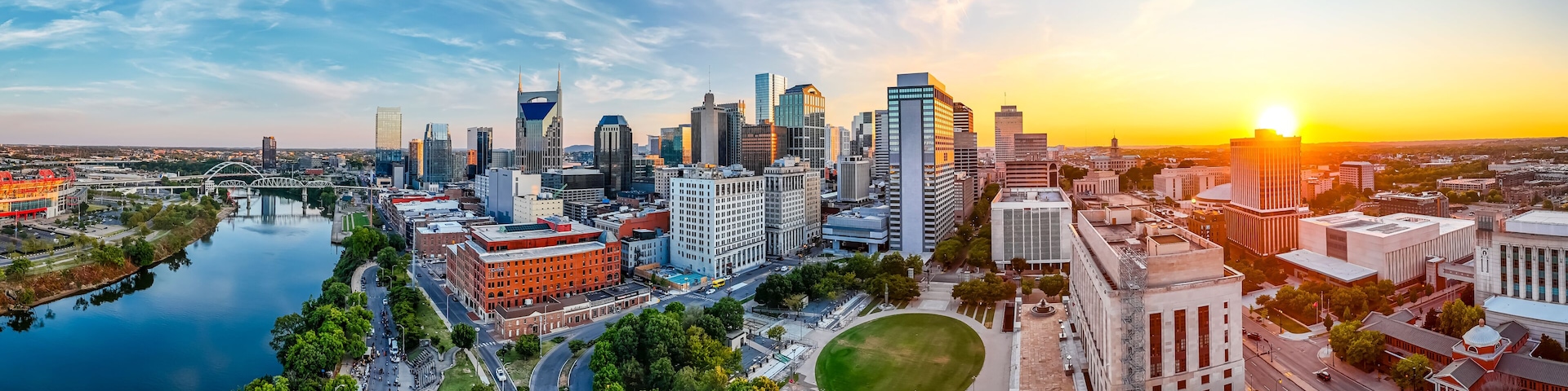 Panoramic view of Nashville skyline at sunset with river, skyscrapers, and city landmarks