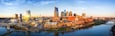 A city skyline with modern skyscrapers, a river, and a bridge.