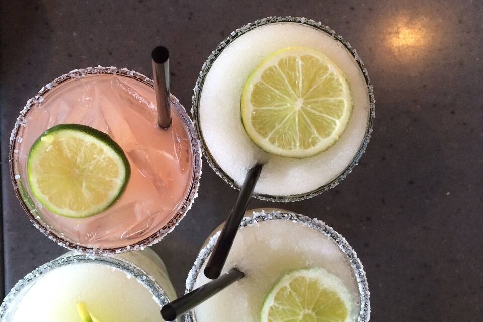Four margaritas on a metal surface.
