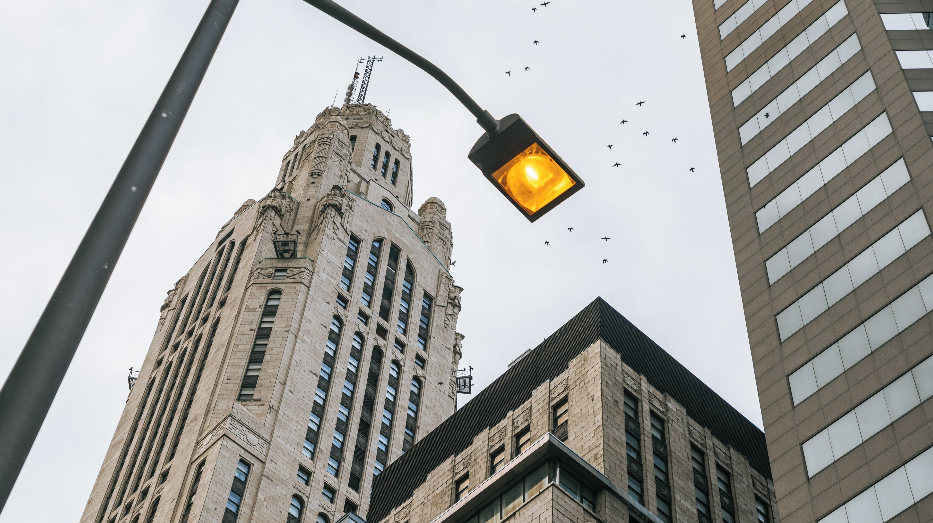 Un edificio alto y ornamentado con detalles arquitectónicos intrincados y una farola con luz brillante.