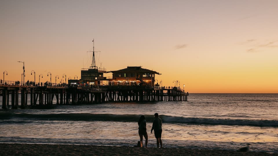Downtown Santa Monica which includes general coastal views and a sunset as well as a couple