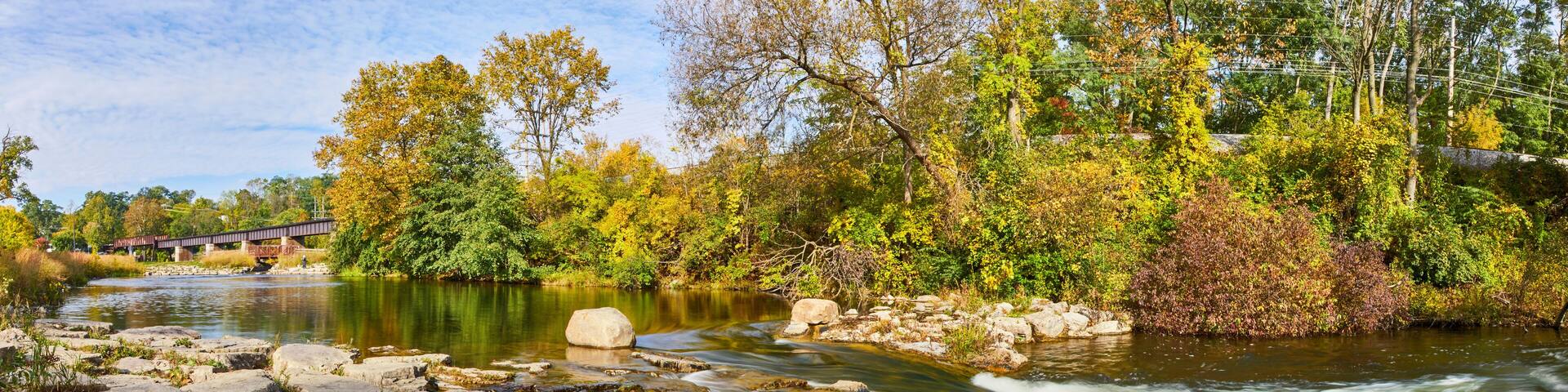 Serene River with Covered Bridge and Autumn Foliage Panorama