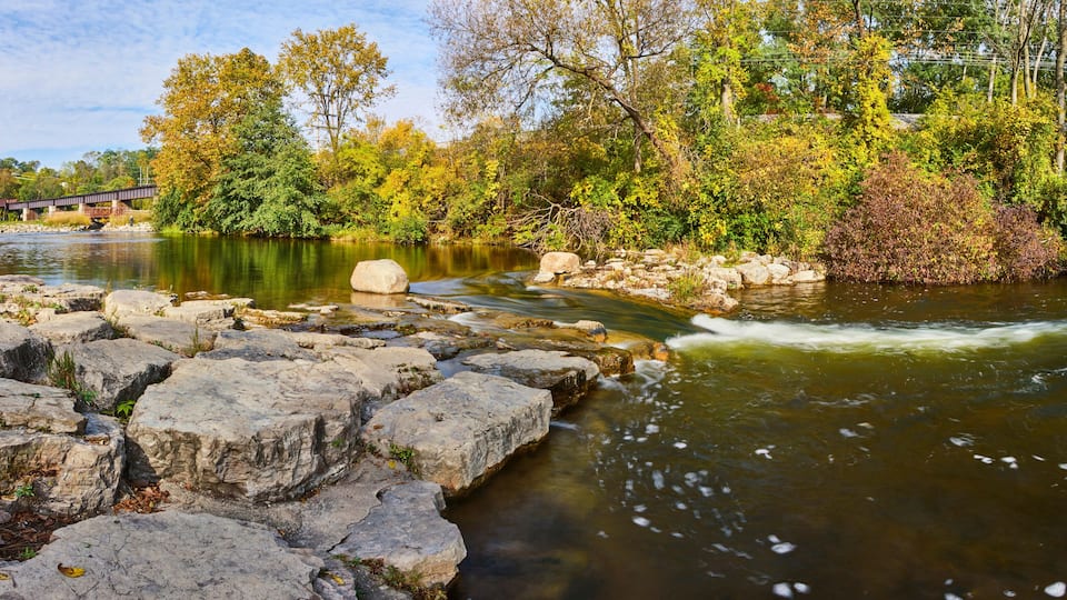 Serene River with Covered Bridge and Autumn Foliage Panorama