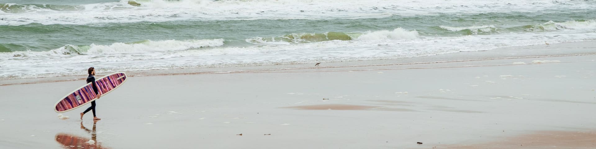 Andy Romano Beachfront Park featuring a sandy beach and general coastal views as well as an individual male