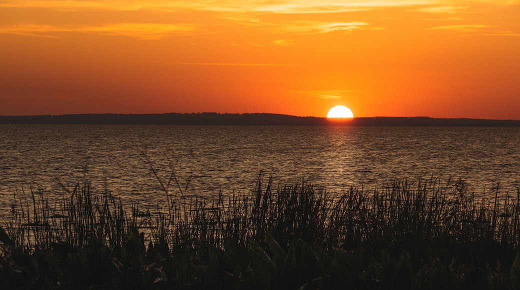 Orange sunset over distant hills on Lake Apopka near Orlando, Florida.