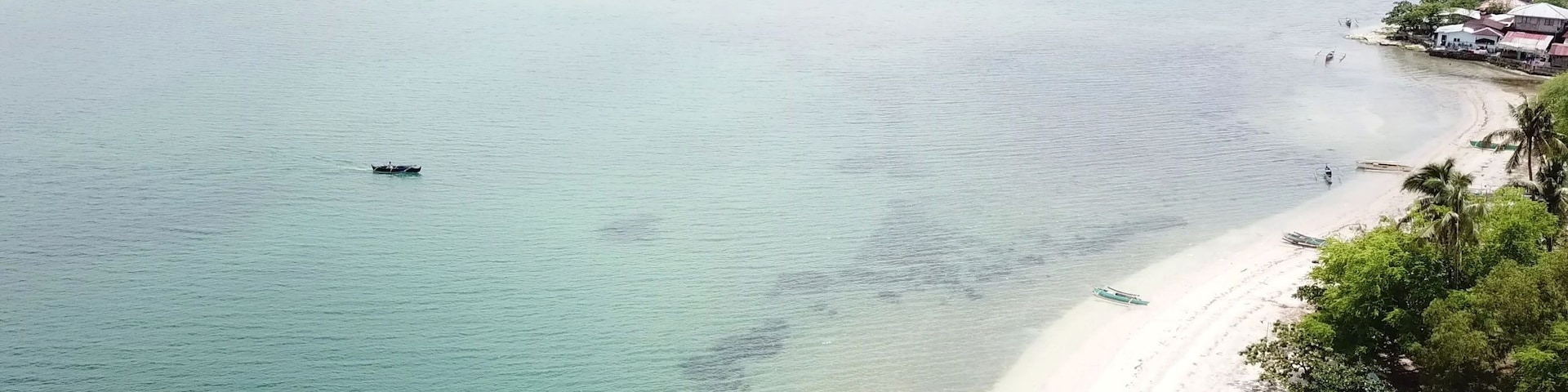 High angle landscape view of beautiful beach with sand and clear turquoise water with coastal feature in Masinloc, Zambales, Philippines