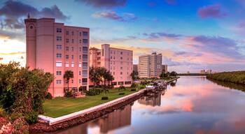 A river with buildings on both sides, a clear sky, and a sunset.