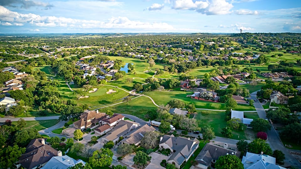A bird's-eye view of the surroundings of residential buildings and beautiful green fields. Houston, Texas, USA. Development of suburban housing construction. general plan
