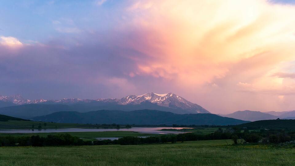 Scenic view of landscape against cloudy sky during sunset