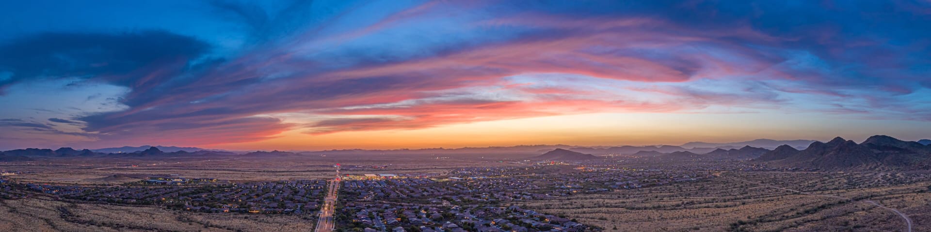 Panoramic aerial view of a desert community in Arizona during the golden hour at sunset.