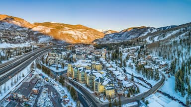 A snow-covered town with a highway, buildings, and mountains in the background.