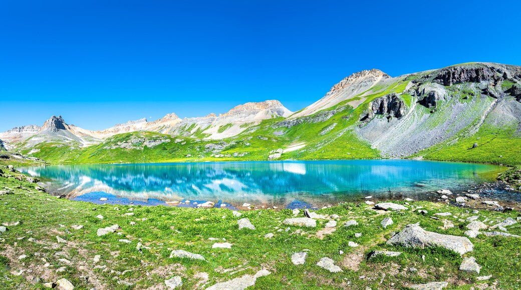 Panoramic view of beautiful Ice lake near Silverton, Colorado on rocky mountain peak and panorama reflection of summer landscape with nobody and green grass blue sky