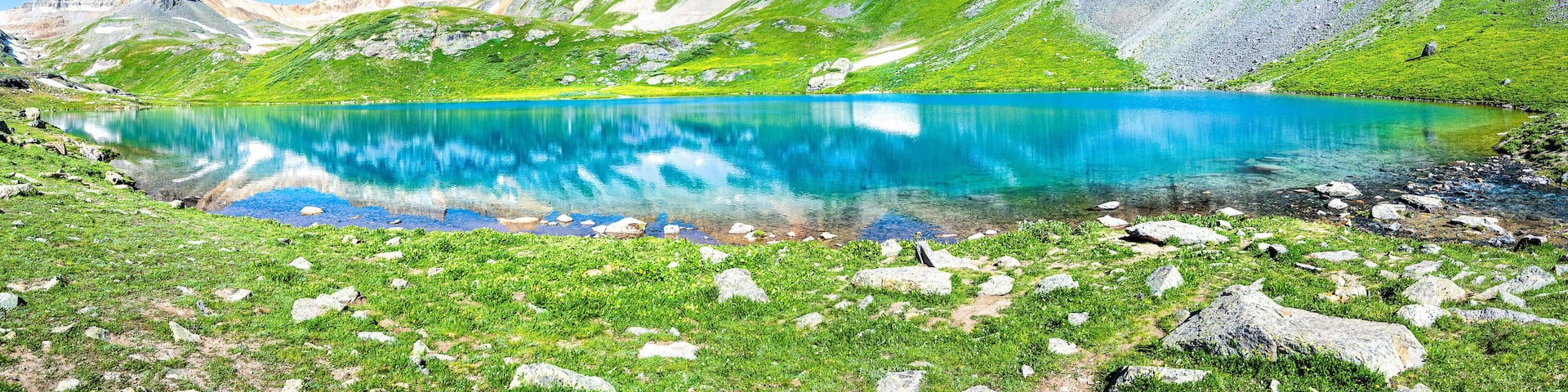 Panoramic view of beautiful Ice lake near Silverton, Colorado on rocky mountain peak and panorama reflection of summer landscape with nobody and green grass blue sky