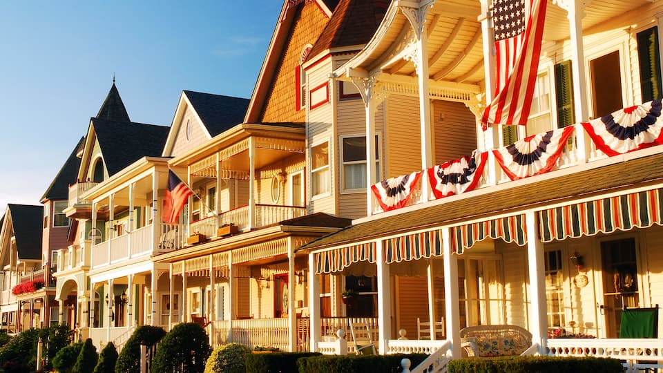 A row of historic houses with American flags and festive decorations.