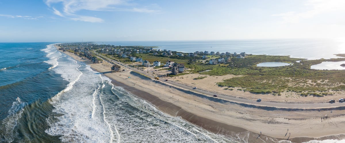 A coastal town with a beach, ocean, and residential areas.